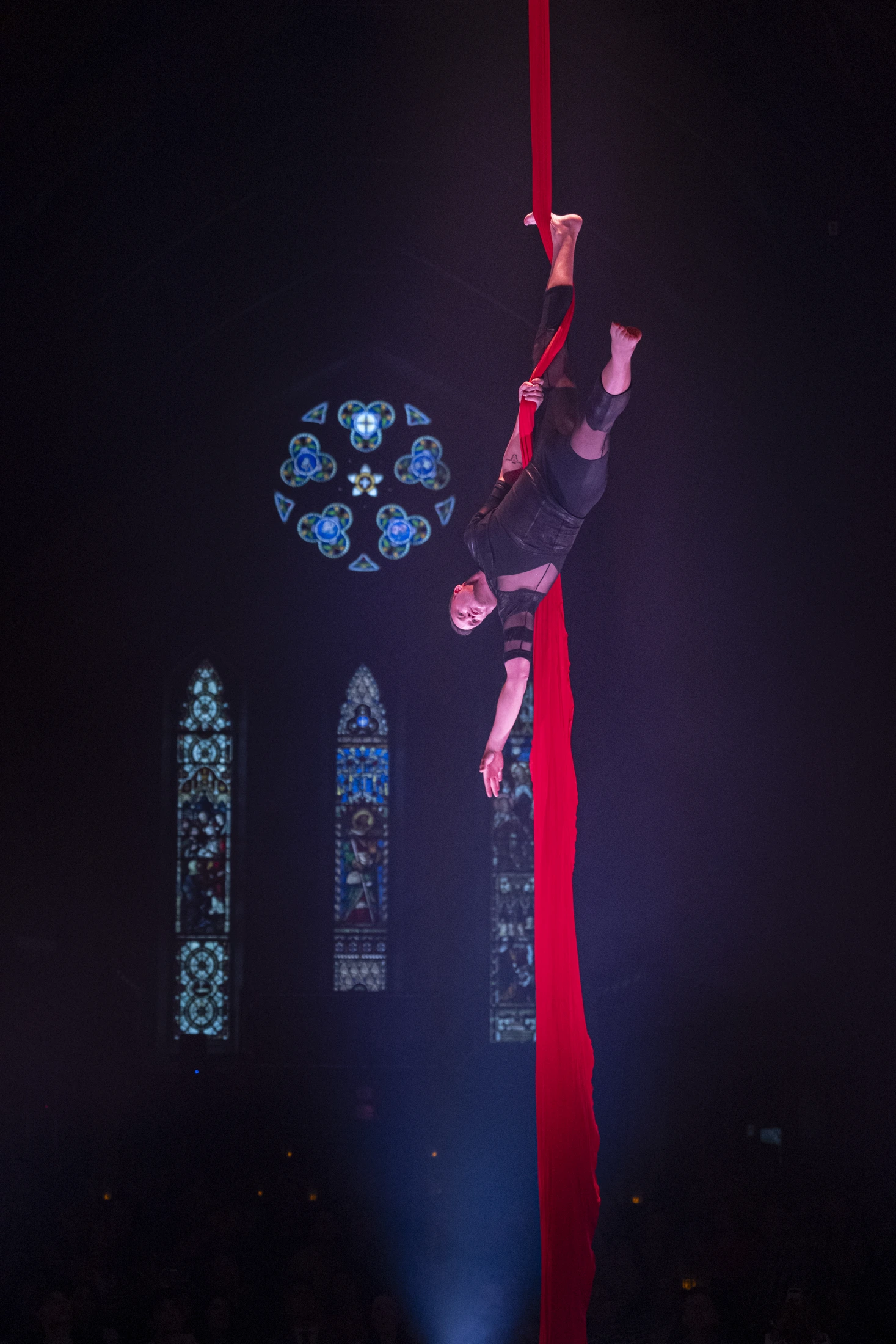Pascal Lépine suspendu tête en bas dans le tissu aérien du spectacle Envol.