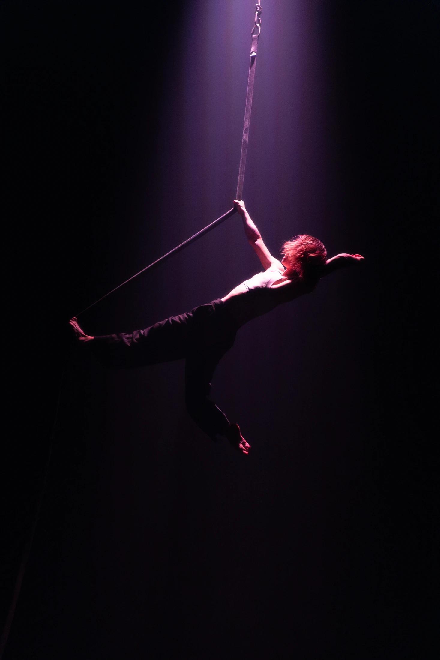 Un interprète étend son corps dans une figure aérienne suspendue, photographiée par Harmony Le Reste.